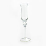 A tall, slender, clear glass champagne flute is set against a plain white background, showcasing the refined elegance characteristic of an Optic White Wine Glass (25 rack). Its narrow bowl and long stem amplify its sophisticated allure. If youre hosting an event in Atlanta and need exquisite glass rentals, T3 Event Rentals has the perfect selection for you.