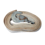 A rugged beige ratchet strap, coiled and featuring a metal hook on one end, is showcased against a white background. The straps wear and the rust on the hook make it perfectly suited for rental purposes. Ideal for those in the Dawsonville area seeking reliable equipment.