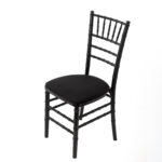 The Black Chiavari Chair, perfect for rentals in Atlanta, is elegantly displayed with a slight left angle against a clean white background. This chair, offered by T3 Event Rentals, showcases a luxurious padded seat, classic spindle backrest, and sleek straight legs—ideal for elevating your event decor.