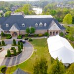 Experience unforgettable events in Dahlonega with T3 Event Rentals! Our elegant sailcloth rope and pole tent is set up on lush green lawns, beside a stunning lake and surrounded by trees. The impressive stone and brick building with a circular driveway provides the perfect backdrop for your event rentals in Dahlonega. Trust T3 Event Rentals for all your rental needs—tables, chairs, tents, and more—for weddings or special gatherings throughout the Dahlonega area.