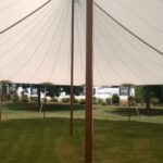 Sailcloth tent at night with perimeter lighting and LED uplights