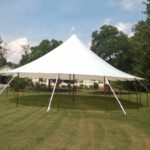 Sailcloth tent at night with perimeter lighting and LED uplights