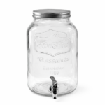A clear glass beverage dispenser with a metal screw-on lid and spigot at the bottom, available for rent from T3 Event Rentals in Dahlonega. Perfect for events, this dispenser is displayed on a white surface against a plain gray background. All items are rentals—nothing for sale!.