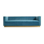 A modern blue upholstered sofa rental from T3 Event Rentals, featuring clean lines, low armrests, and a stylish wooden base, available for events throughout Forsyth County. Perfect as an elegant lounge piece for your next celebration—reserve with T3 Event Rentals today!.