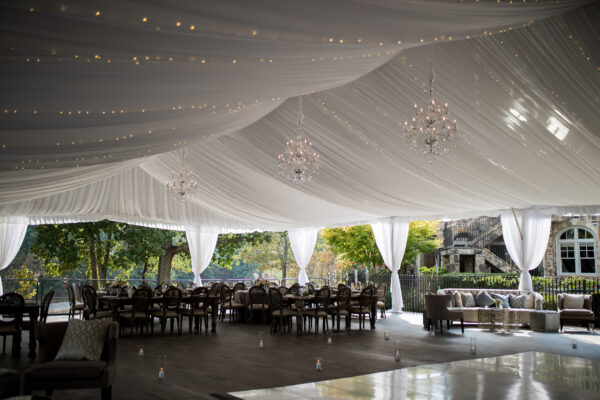 T3 Event Rentals brings elegant sofas, tables, and chandeliers to Dahlonega venues with white draped ceilings and greenery views.