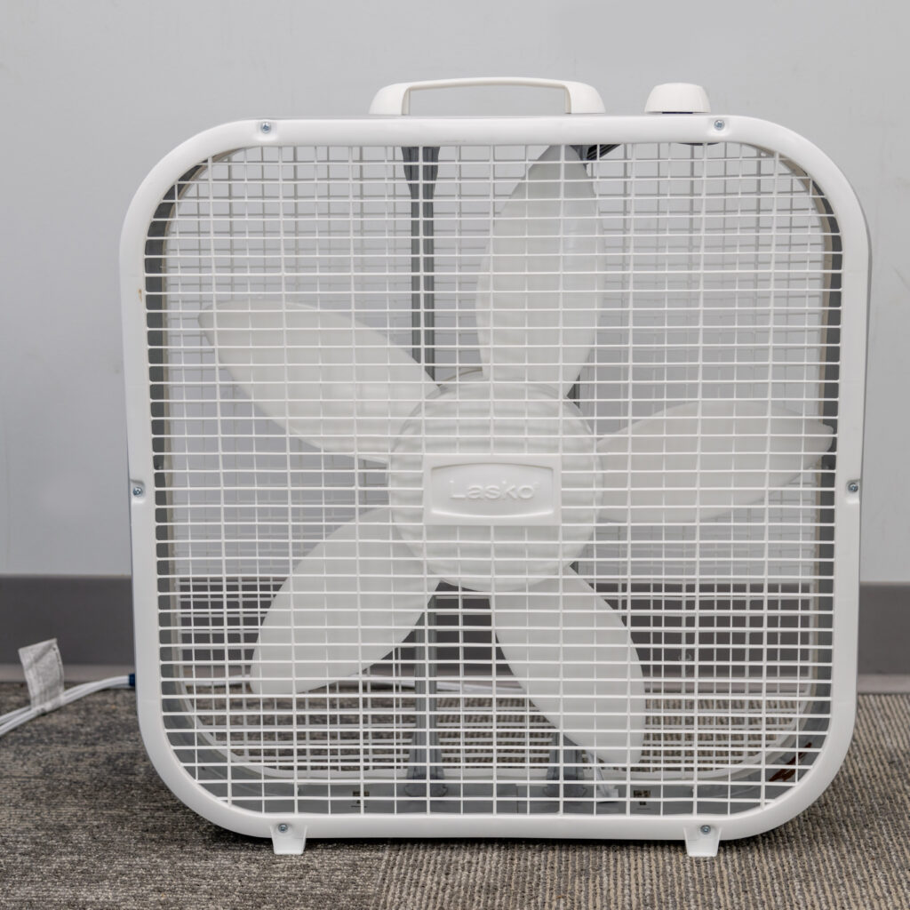 A five-blade box fan from T3 Event Rentals sits on carpet in Dawsonville, ready for your next event rental. Brand visible.