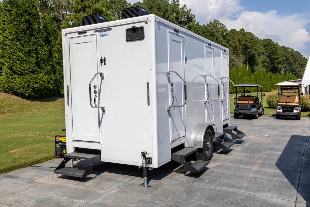 Four stall restroom trailer with climate control, steps and levelling jacks set on a paved drive