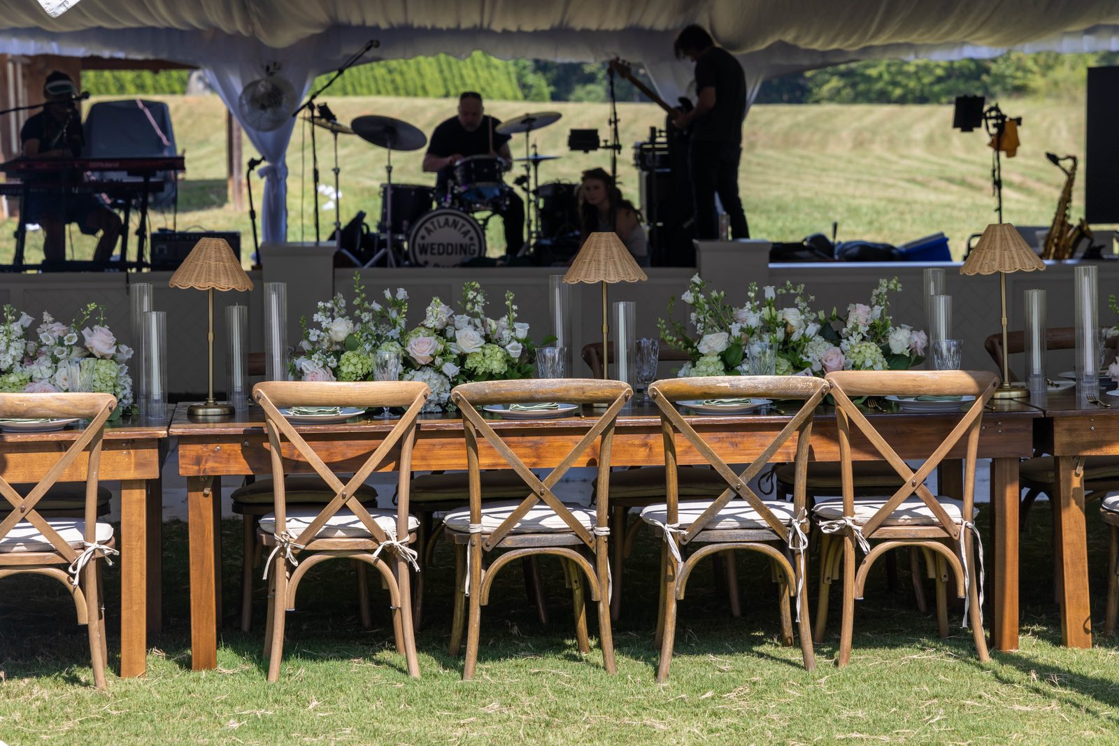 Fruitwood farm tables with driftwood crossback chairs in front of the stage.