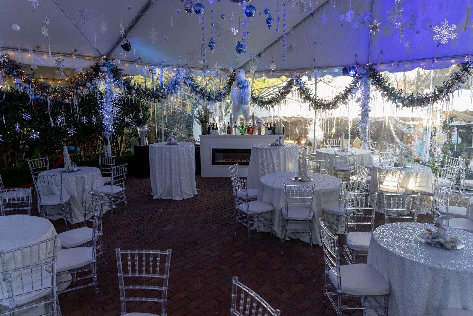Wide view inside the tent with tables set and sidewalls closed around the room.