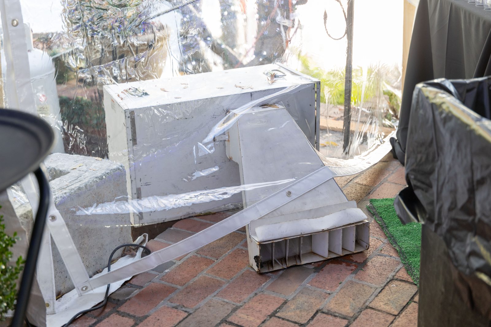 Flexible heater duct passing under the tent wall to carry warm air inside.